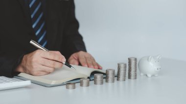 Person with pile of coins and piggy bank, money saving concept for future use and financial stability, salary management, personal finance, investment savings.