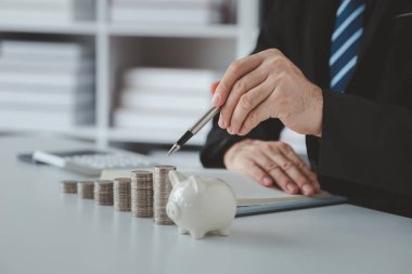 Person with pile of coins and piggy bank, money saving concept for future use and financial stability, salary management, personal finance, investment savings.