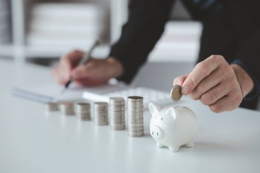 Yığınla parası ve kumbarası olan kişi, gelecekteki kullanım ve mali istikrar için para tasarrufu kavramı, maaş yönetimi, kişisel finans, yatırım tasarrufu.