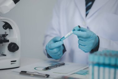 Laboratuvar asistanı, tıp bilimcisi, kimya araştırmacısı kimyasal test tüpünden cam bir tüp tutuyor, kimyasal deney yapıyor ve hastanın örneğini inceliyor. Tıp ve araştırma konsepti.