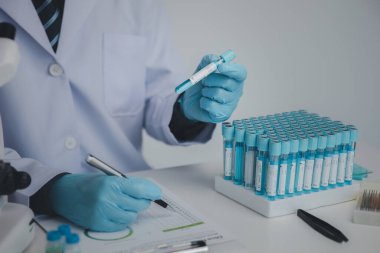 Laboratuvar asistanı, tıp bilimcisi, kimya araştırmacısı kimyasal test tüpünden cam bir tüp tutuyor, kimyasal deney yapıyor ve hastanın örneğini inceliyor. Tıp ve araştırma konsepti.