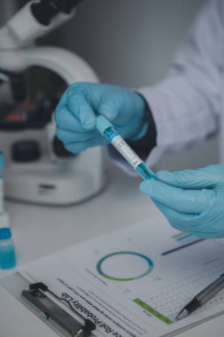 Laboratuvar asistanı, tıp bilimcisi, kimya araştırmacısı kimyasal test tüpünden cam bir tüp tutuyor, kimyasal deney yapıyor ve hastanın örneğini inceliyor. Tıp ve araştırma konsepti.