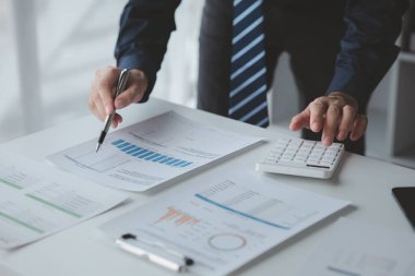 Şirketindeki özel bir ofiste iş adamı ve şirketin mali belgelerini inceliyor, üst düzey yönetim finansal bilgilerin doğruluğunu kontrol ediyor. Mali yönetim.