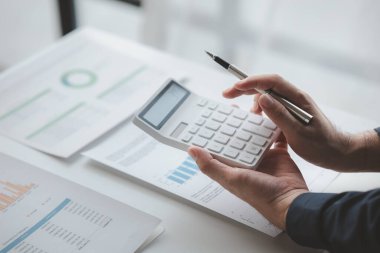 Şirketindeki özel bir ofiste iş adamı ve şirketin mali belgelerini inceliyor, üst düzey yönetim finansal bilgilerin doğruluğunu kontrol ediyor. Mali yönetim.