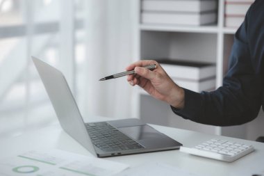 Şirketindeki özel bir ofiste iş adamı ve şirketin mali belgelerini inceliyor, üst düzey yönetim finansal bilgilerin doğruluğunu kontrol ediyor. Mali yönetim.