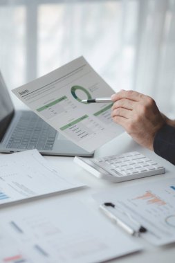 Şirketindeki özel bir ofiste iş adamı ve şirketin mali belgelerini inceliyor, üst düzey yönetim finansal bilgilerin doğruluğunu kontrol ediyor. Mali yönetim.