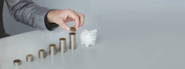 stock image Person with pile of coins and piggy bank, money saving concept for future use and financial stability, salary management, personal finance, investment savings.