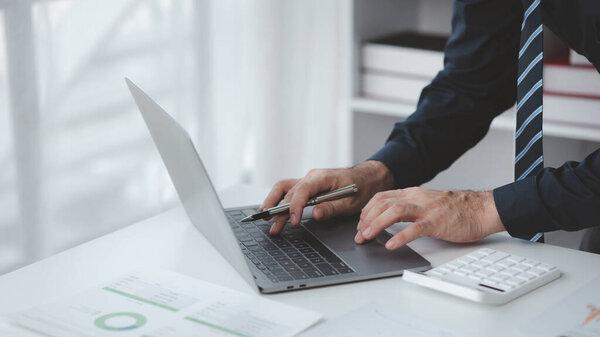 Businessman in a private office at his company and is reviewing company financial documents, senior management checking financial information for accuracy. Financial management.