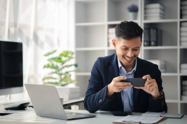 Ofiste çalışan ve cep telefonu kullanan bir adam, genç bir iş adamı, modern işletme yöneticisi, gençler tarafından işletilen bir şirket, yeni fikirleri olan modern bir girişimci. İşletme lideri olmak.