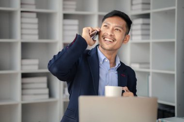 Ofiste çalışan ve telefonda konuşan bir adam, genç bir iş adamı, modern işletme yöneticisi, gençler tarafından işletilen bir şirket, yeni fikirleri olan modern bir girişimci. İşletme lideri olmak.