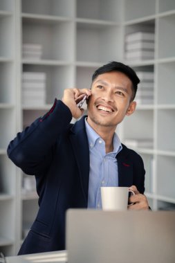 Ofiste çalışan ve telefonda konuşan bir adam, genç bir iş adamı, modern işletme yöneticisi, gençler tarafından işletilen bir şirket, yeni fikirleri olan modern bir girişimci. İşletme lideri olmak.