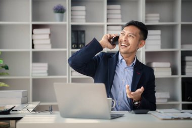 Ofiste çalışan ve telefonda konuşan bir adam, genç bir iş adamı, modern işletme yöneticisi, gençler tarafından işletilen bir şirket, yeni fikirleri olan modern bir girişimci. İşletme lideri olmak.