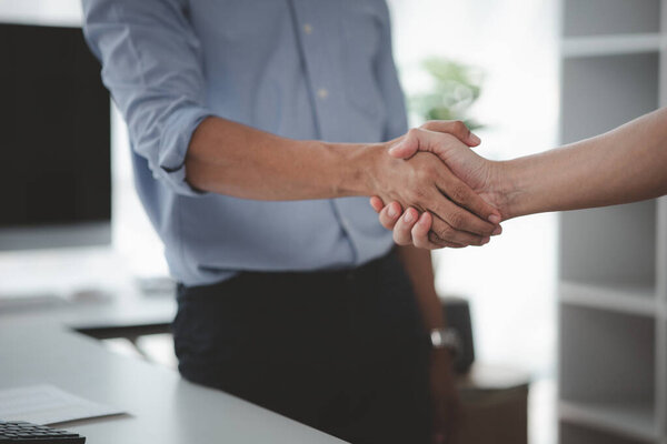 Business investor group holding hands, Two businessmen are agreeing on business together and shaking hands after a successful negotiation. Handshaking is a Western greeting or congratulation.