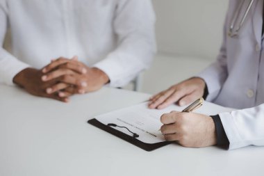Doktor ve hasta tedavinin detaylarını, hastanın fiziksel muayenesinin sonuçlarını tartışıyorlar. Yıllık fiziksel muayene kavramı.