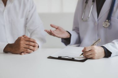 Doktor ve hasta tedavinin detaylarını, hastanın fiziksel muayenesinin sonuçlarını tartışıyorlar. Yıllık fiziksel muayene kavramı.