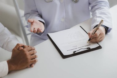 Doktor ve hasta tedavinin detaylarını, hastanın fiziksel muayenesinin sonuçlarını tartışıyorlar. Yıllık fiziksel muayene kavramı.