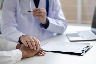 Doktor ve hasta tedavinin detaylarını, hastanın fiziksel muayenesinin sonuçlarını tartışıyorlar. Yıllık fiziksel muayene kavramı.