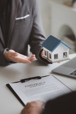 Real estate agents explain models of housing estates in projects to elaborate to clients, explaining and presenting information about homes and purchasing loans. Real estate trading concept.
