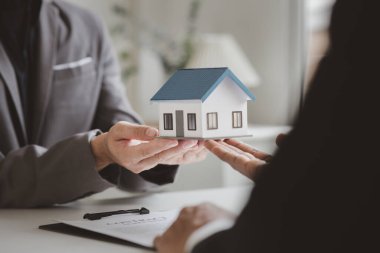 Real estate agents explain models of housing estates in projects to elaborate to clients, explaining and presenting information about homes and purchasing loans. Real estate trading concept.