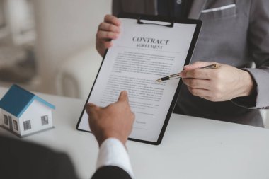 Real estate agents explain models of housing estates in projects to elaborate to clients, explaining and presenting information about homes and purchasing loans. Real estate trading concept.