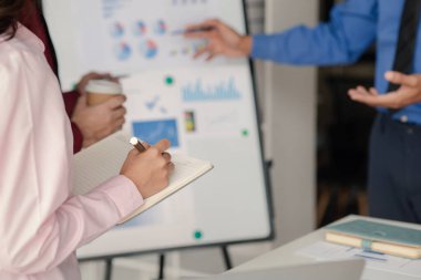 Şirket toplantı odasında iş adamları ve finans yöneticileri iş planı konusunda bir araya geliyor. Belgeler hakkında bilgi topluyor ve birlikte tartışıyorlar. İş planlama yönetimi kavramı.