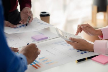 The sales department is having a monthly summary meeting to bring it to the department manager, they are verifying the correctness of the documents that are prepared before bringing in to the manager.