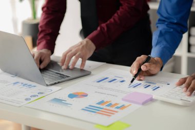 Businessman is reviewing monthly sales documents for analysis and marketing plans for more sales growth, they are the founders of young companies co-founding startups. Sales management concept.