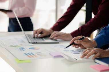 Businessman is reviewing monthly sales documents for analysis and marketing plans for more sales growth, they are the founders of young companies co-founding startups. Sales management concept.