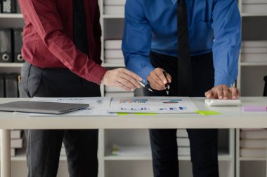 Businessman is reviewing monthly sales documents for analysis and marketing plans for more sales growth, they are the founders of young companies co-founding startups. Sales management concept.