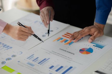 Businessman is reviewing monthly sales documents for analysis and marketing plans for more sales growth, they are the founders of young companies co-founding startups. Sales management concept.
