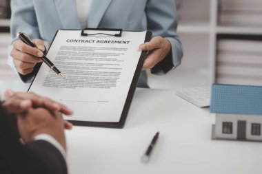 Real estate agents explain models of housing estates in projects to elaborate to clients, explaining and presenting information about homes and purchasing loans. Real estate trading concept.