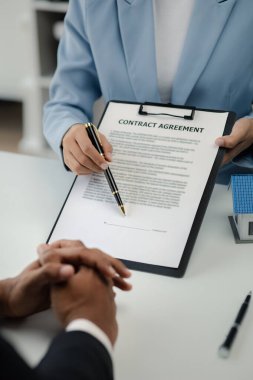 Real estate agents explain models of housing estates in projects to elaborate to clients, explaining and presenting information about homes and purchasing loans. Real estate trading concept.