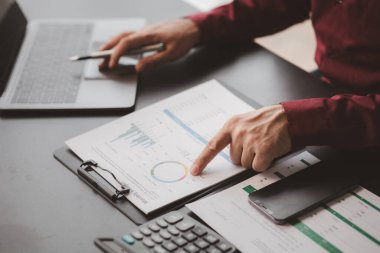 Business man checking financial documents, he owns a startup company, he sits checking the company's financial summary prepared by the finance department. Management concept of startup company.	