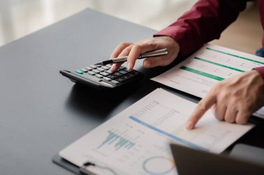 İşadamı, şirketin mali bilgilerini gösteren bir pasta grafiğine işaret ederek şirketin mali bilgilerini harita halinde gösteren özel ofisinde oturuyor. Finansal kavramlar.