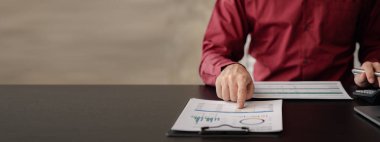 İşadamı, şirketin mali bilgilerini gösteren bir pasta grafiğine işaret ederek şirketin mali bilgilerini harita halinde gösteren özel ofisinde oturuyor. Finansal kavramlar.