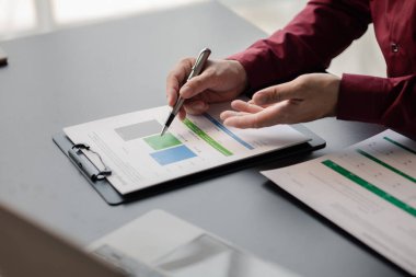 İşadamı, şirketin mali bilgilerini gösteren bir pasta grafiğine işaret ederek şirketin mali bilgilerini harita halinde gösteren özel ofisinde oturuyor. Finansal kavramlar.