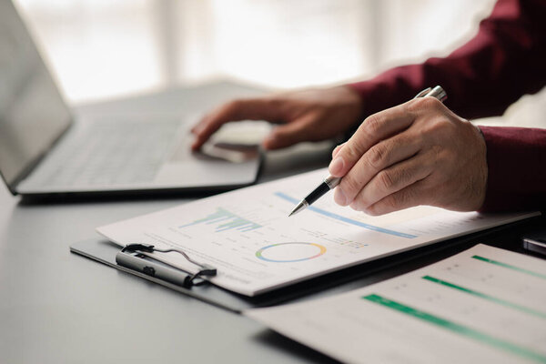 Business men are looking at the company's financial documents to analyze problems and find solutions before bringing the information to a meeting with a partner. Financial concept.