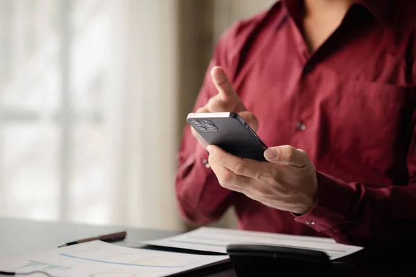 stock image A person holds a mobile phone to use social media on a smartphone, communicating via the Internet on a smartphone. The concept of using technology in communication.	