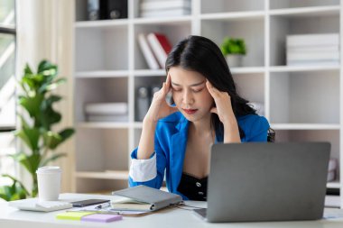 Uzun çalışma saatleri ve iş sorunları yüzünden stres altında olan güzel Asyalı kadın, aşırı çalışma yüzünden ofis sendromu geçiren genç iş kadını, ağrıya ve baş ağrısına neden oluyor. Ofis sendromu kavramı.