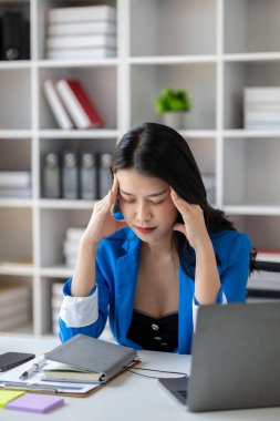Uzun çalışma saatleri ve iş sorunları yüzünden stres altında olan güzel Asyalı kadın, aşırı çalışma yüzünden ofis sendromu geçiren genç iş kadını, ağrıya ve baş ağrısına neden oluyor. Ofis sendromu kavramı.