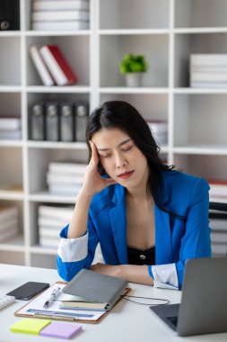 Uzun çalışma saatleri ve iş sorunları yüzünden stres altında olan güzel Asyalı kadın, aşırı çalışma yüzünden ofis sendromu geçiren genç iş kadını, ağrıya ve baş ağrısına neden oluyor. Ofis sendromu kavramı.