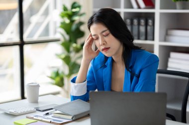 Uzun çalışma saatleri ve iş sorunları yüzünden stres altında olan güzel Asyalı kadın, aşırı çalışma yüzünden ofis sendromu geçiren genç iş kadını, ağrıya ve baş ağrısına neden oluyor. Ofis sendromu kavramı.