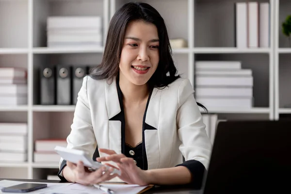 オフィスで働く若い美しいアジア人女性 成長と近代化のために熱心にオフィスで働くビジネス女性 彼女は会社の市場と財務データを分析しています — ストック写真