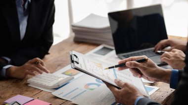 The sales department is having a monthly summary meeting to bring it to the department manager, they are verifying the correctness of the documents that are prepared before bringing in to the manager