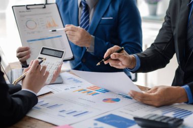Businessman is reviewing monthly sales documents for analysis and marketing plans for more sales growth, they are the founders of young companies co-founding startups. Sales management concept.