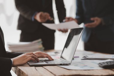 Businessman is reviewing monthly sales documents for analysis and marketing plans for more sales growth, they are the founders of young companies co-founding startups. Sales management concept.