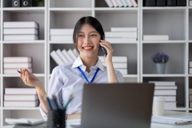 Telefonda konuşan Asyalı bir kadın, bir girişim şirketinde satış elemanı, ürün ve promosyon satmak için müşterileri arıyor. Telefon kanalları aracılığıyla ürün satma kavramı.