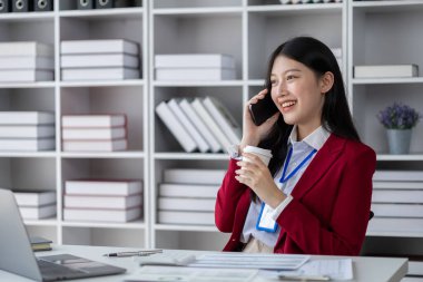 Telefonda konuşan Asyalı bir kadın, bir girişim şirketinde satış elemanı, ürün ve promosyon satmak için müşterileri arıyor. Telefon kanalları aracılığıyla ürün satma kavramı.