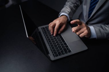 Laptop klavyesinde yazan kişi, dizüstü bilgisayarda çalışan iş adamı, iş arkadaşlarına mesaj yazıyor ve toplantıyı özetlemek için mali bilgi tablosu hazırlıyor..