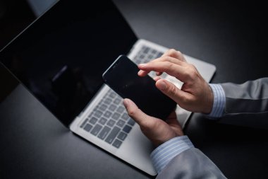 Bir kişi bir telefon tutuyor ve sosyal medya uygulamaları kullanıyor, bir işadamı bilgileri kontrol ediyor ve 5G internet üzerinden hızlı bir şekilde iş yapmak için akıllı telefondan e-postalar gönderiyor. Teknoloji kullanma kavramı.